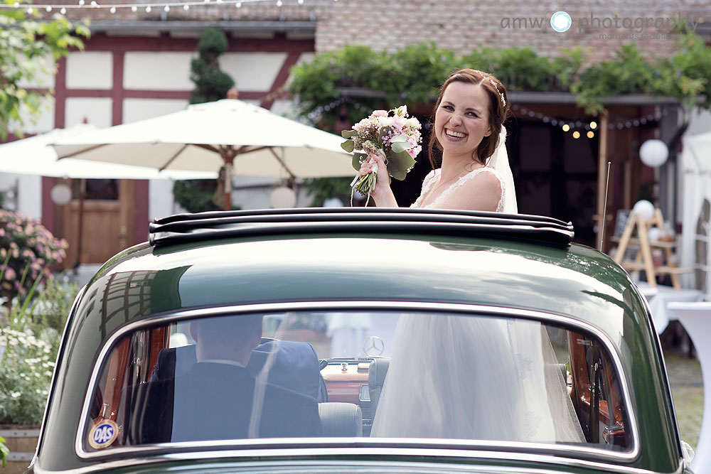 lachende braut im oldtimer hochzeitsauto heiraten in frankfurt hochzeitsfotografin bilder hochzeit fotografieren nidderau hanau taunus hessen